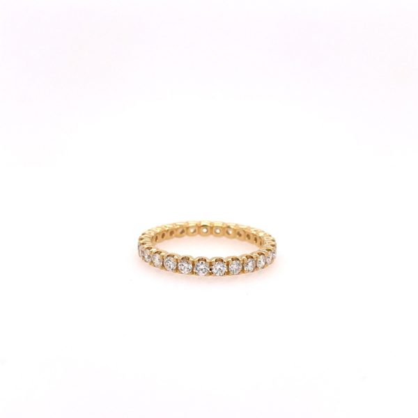 One yellow gold ring, the band filled with pave set round cut diamond, set againts on a white background and surfaced.