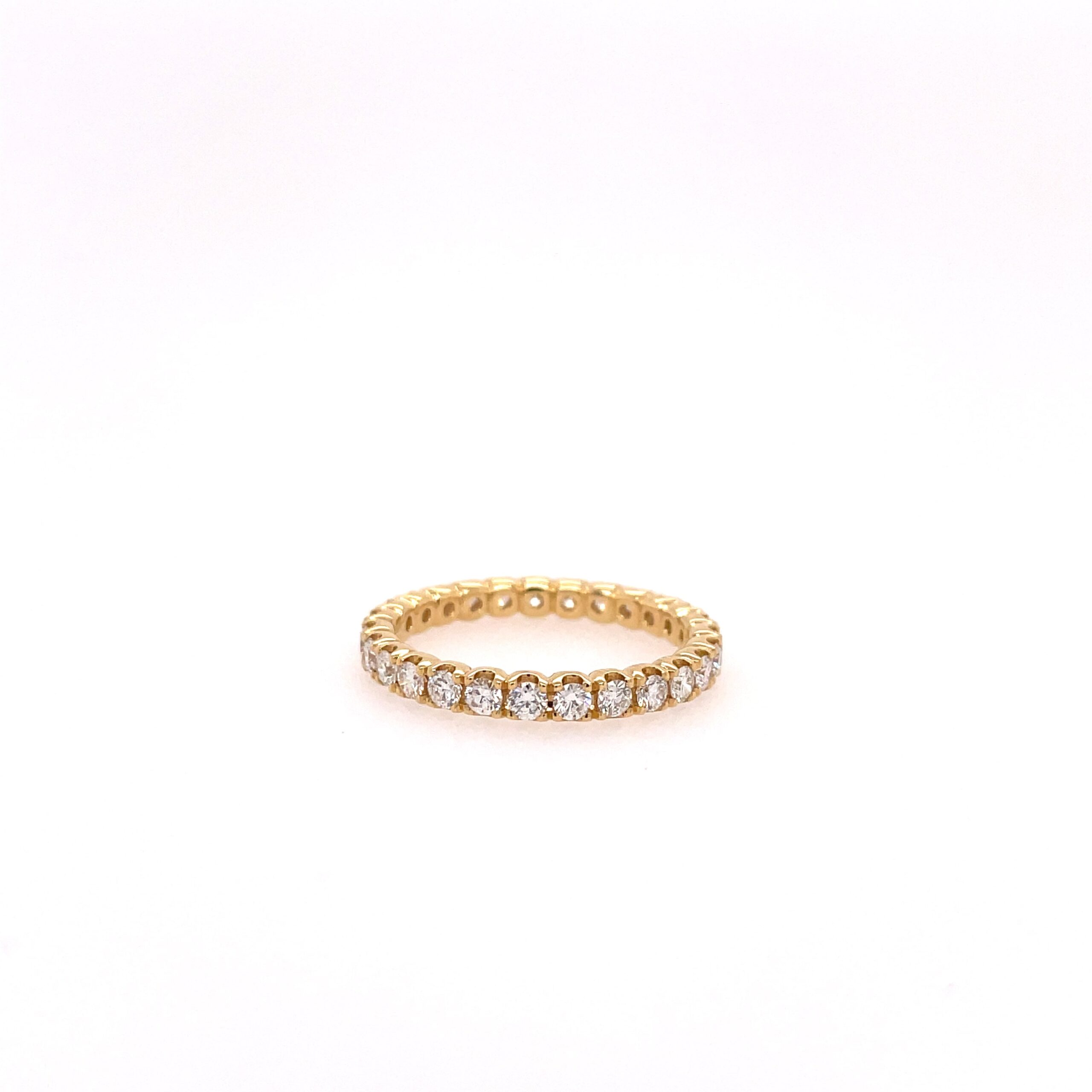 One yellow gold ring, the band filled with pave set round cut diamond, set againts on a white background and surfaced.