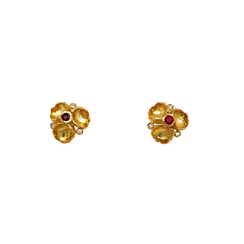 Two yellow gold stud earrings, each earring has a three plated petal design with a ruby gemstone placed in the center. Each has a bezel set diamond on the middle part, separating each petal.