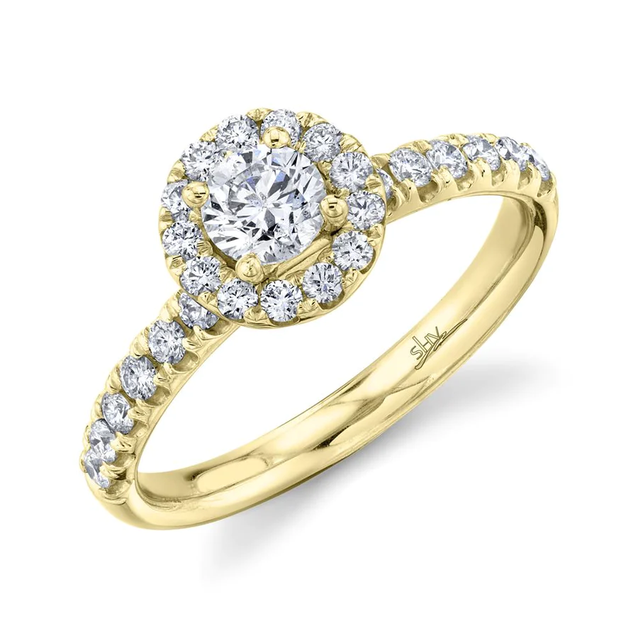 One yellow gold ring with a mounted diamond as focal point of the piece. The ring shoulder has filled with round diamonds, it is on a white background placed slanted from the camera.