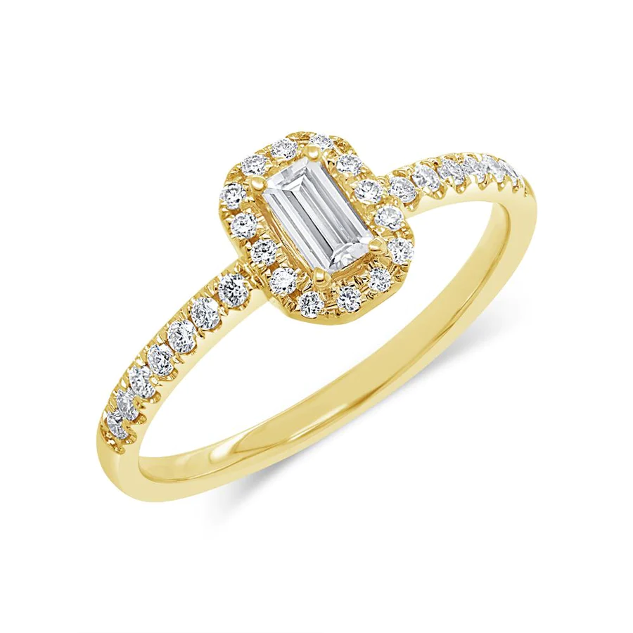 One yellow gold ring in a prong set of emerald diamond filled with pave set smaller diamonds. The ring placed in slanted set againts in a white background.