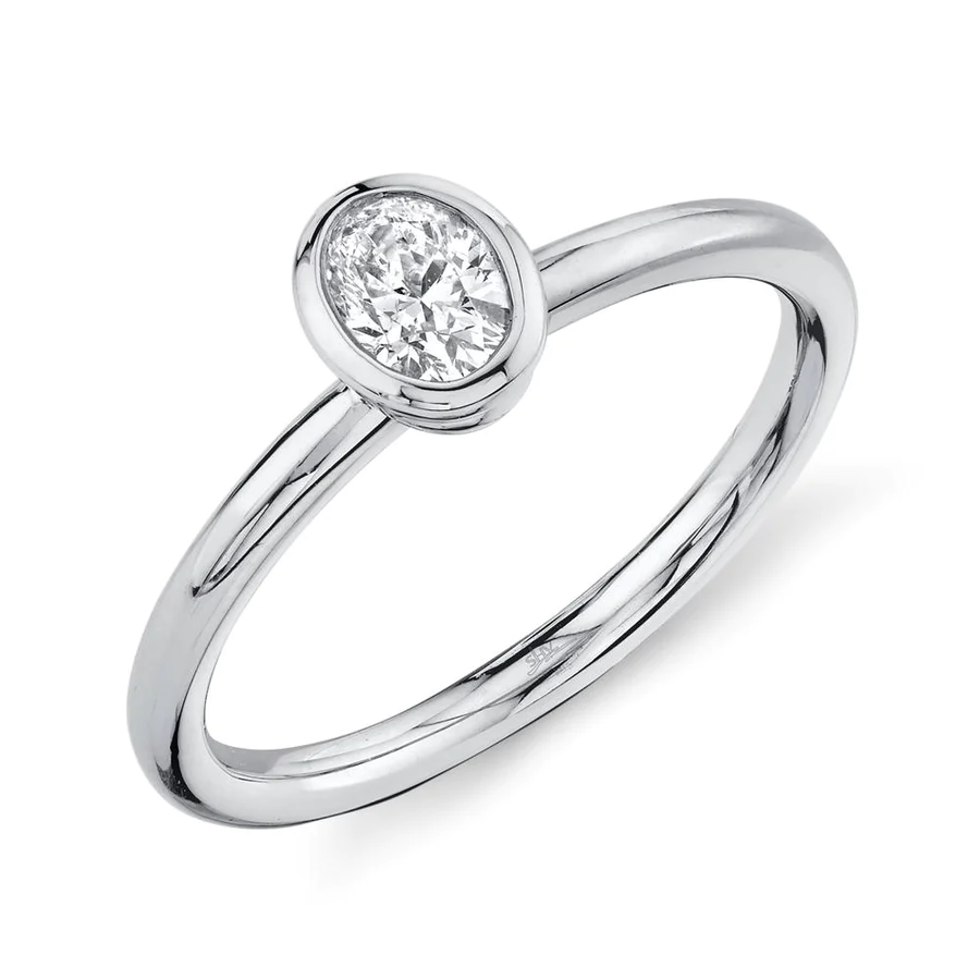 One white gold ring with a plain band and a bezel-set oval center, set against a white background.