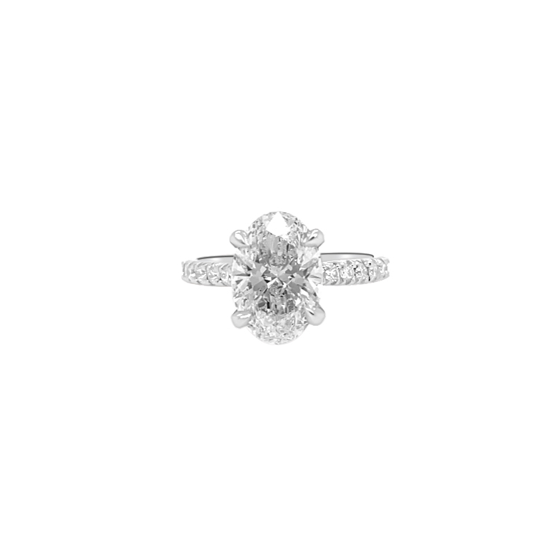One white gold ring features a central oval-shaped diamond with additional diamond accents adorning the ring band.