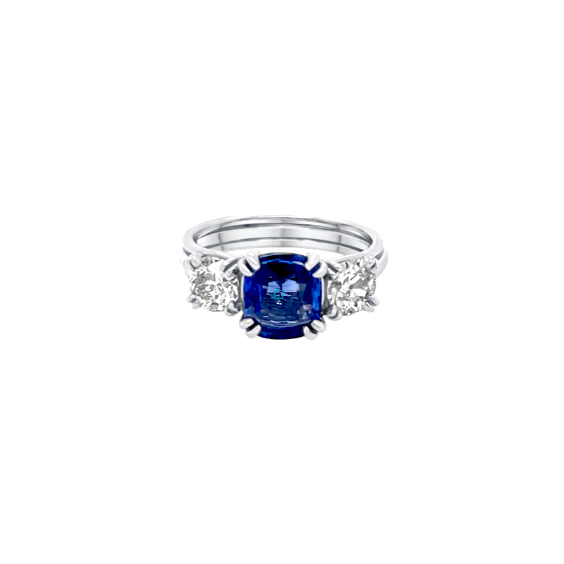 One white gold ring featuring two diamonds flanked by a center-mounted blue gemstone.