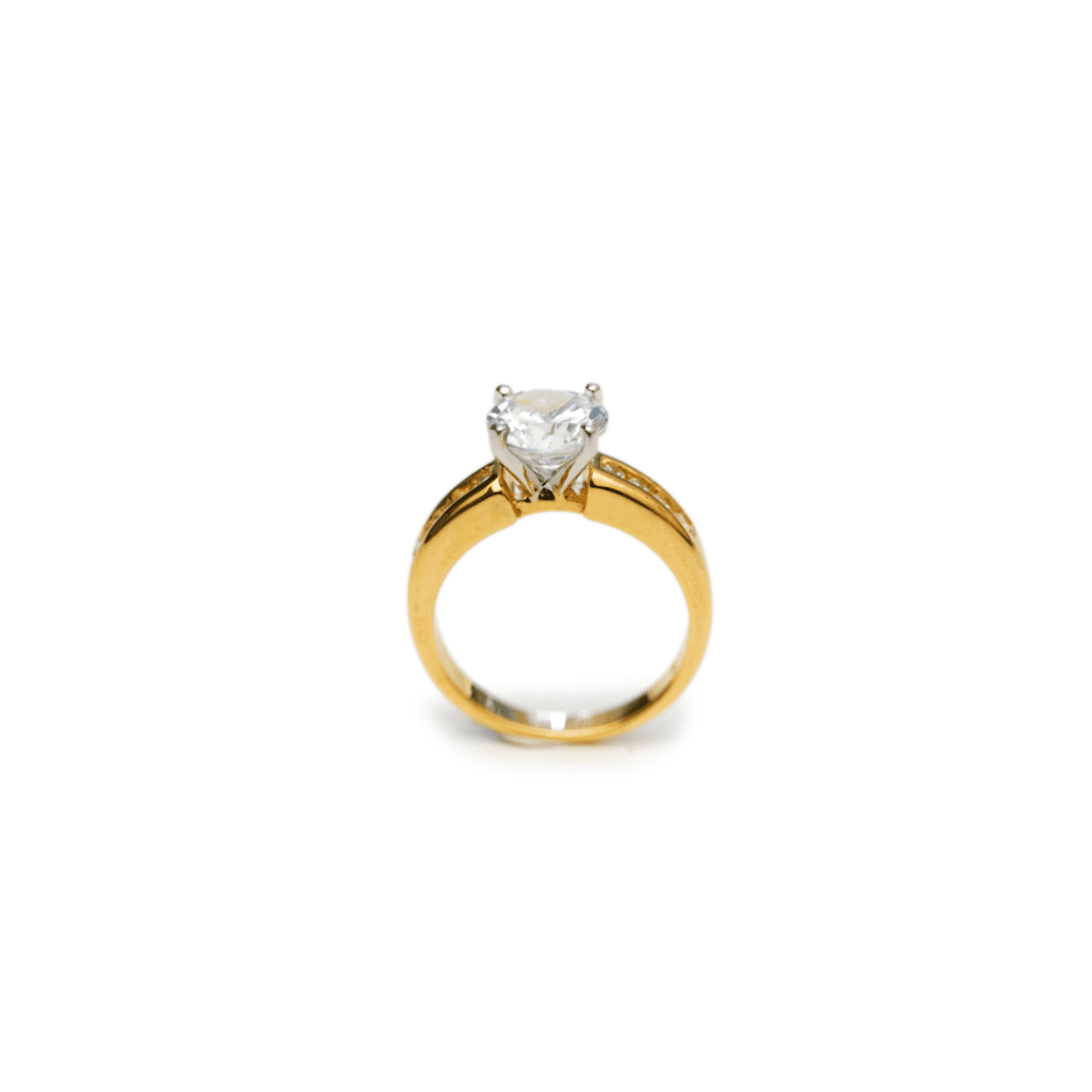 One yellow gold in an upright position against white background. The ring feature a gold band and a mounted single cut diamond.