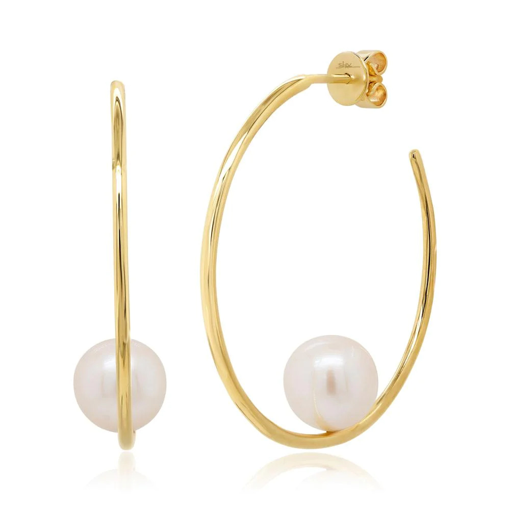 Two yellow gold earrings with a hook-shaped design. The earrings feature a curved hook with a white pearl placed in the middle of the curve.