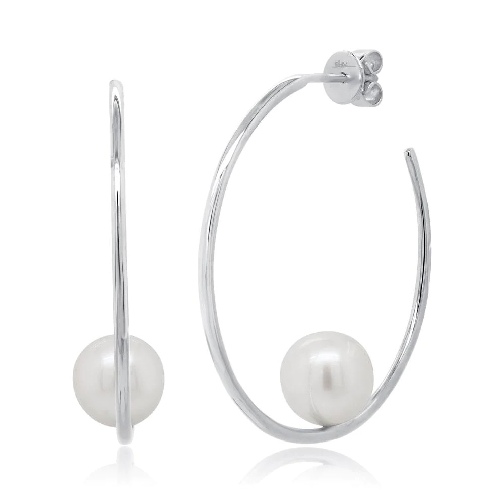 Two white gold earrings with a hook-shaped design. The earrings feature a curved hook with a white pearl placed in the middle of the curve.