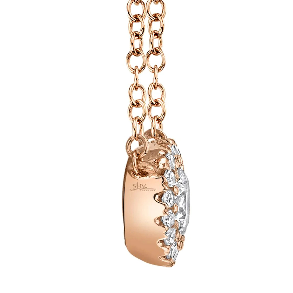 One rose gold necklace facing on the left side from the camera. The necklace features a round pendant has center diamond surrounded by smaller side diamonds.