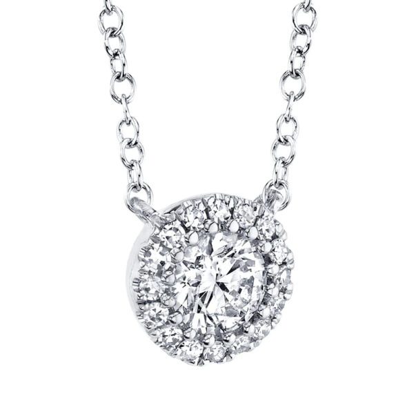 One white gold necklace slightly facing on the left side from the camera. The necklace features a round pendant has center diamond surrounded by smaller side diamonds.