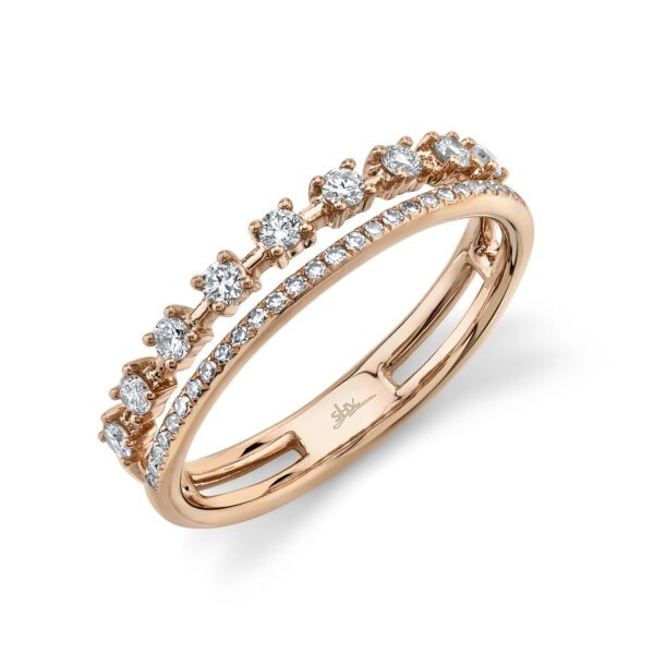 One rose gold ring is positioned slanted toward the camera. The ring showcases a double-row design, giving the illusion of two diamond bands. The first row features diamonds set in prongs, spaced out along the band. The second row of the ring is encrusted with diamonds.