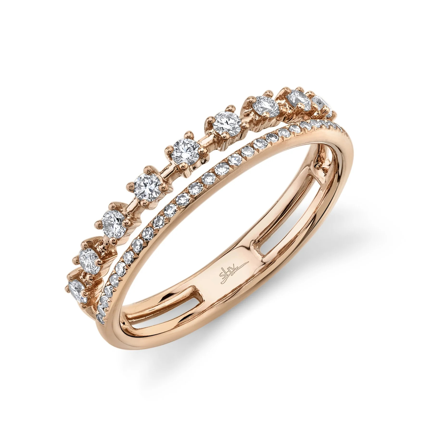 One rose gold ring is positioned slanted toward the camera. The ring showcases a double-row design, giving the illusion of two diamond bands. The first row features diamonds set in prongs, spaced out along the band. The second row of the ring is encrusted with diamonds.