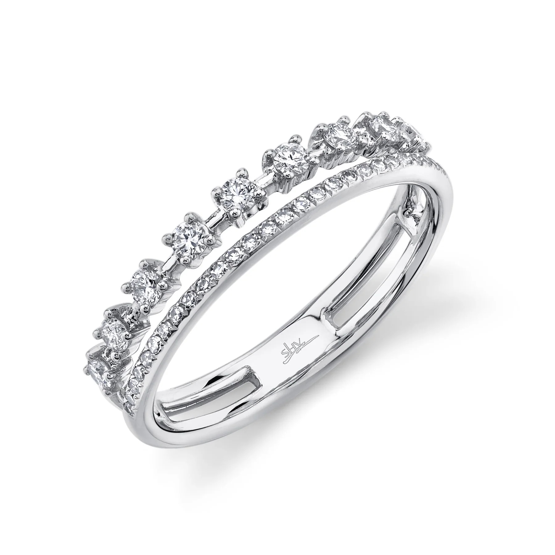One white gold ring is positioned slanted toward the camera. The ring showcases a double-row design, giving the illusion of two diamond bands. The first row features diamonds set in prongs, spaced out along the band. The second row of the ring is encrusted with diamonds.