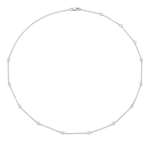 One white necklace. The necklace is a thin chain adorned with small circular elements. The circular elements are evenly spaced along the chain and feature diamonds.