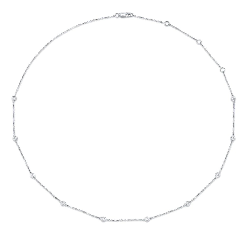One white necklace. The necklace is a thin chain adorned with small circular elements. The circular elements are evenly spaced along the chain and feature diamonds.