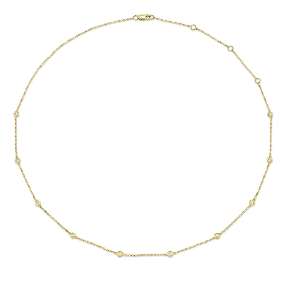 One yellow gold necklace. The necklace is a thin chain adorned with small circular elements. The circular elements are evenly spaced along the chain and feature diamonds.