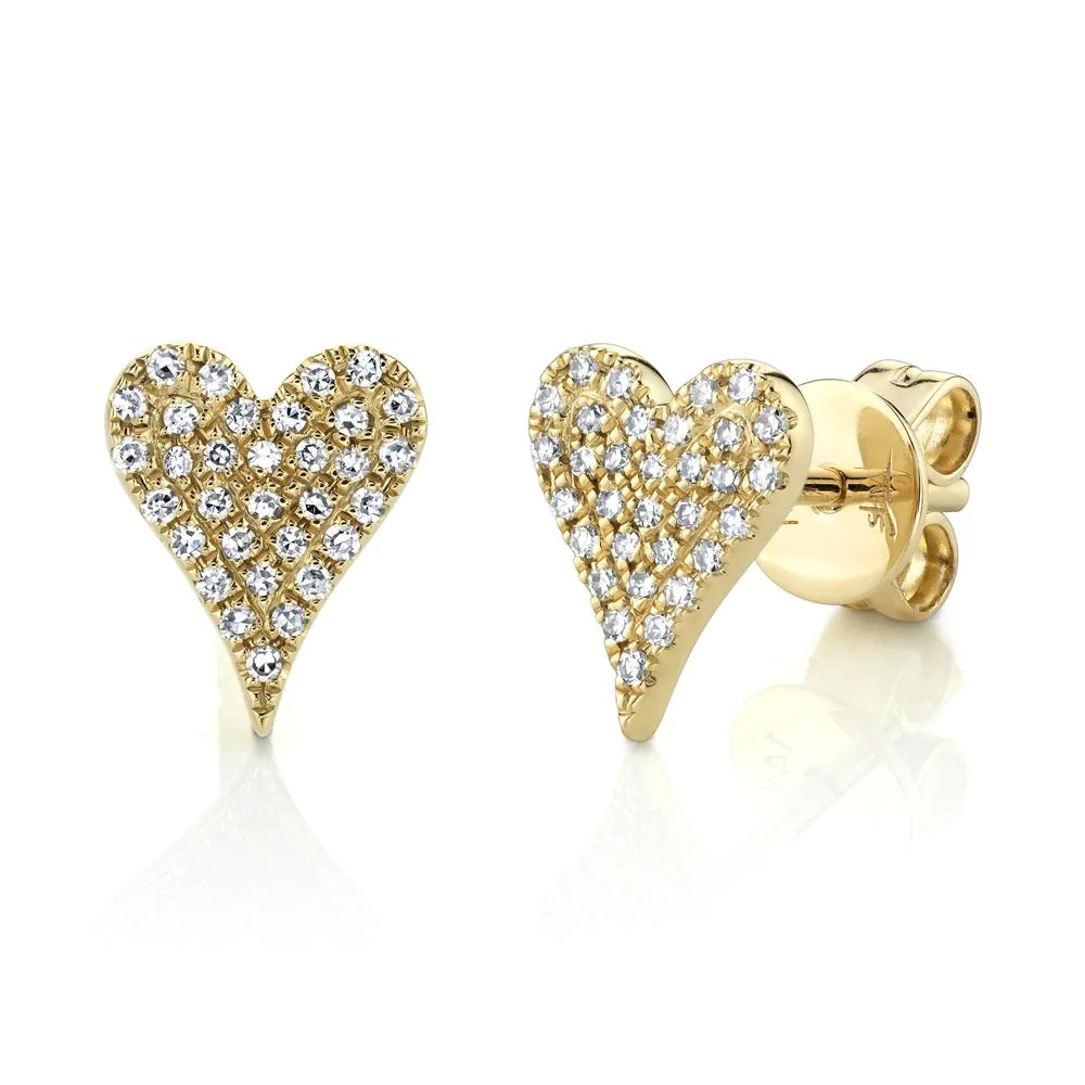 Two yellow gold stud earrings. The earring on the right faces the camera, while the earring on the left faces slightly to the right. The earrings feature a heart-shaped design with diamond stones.