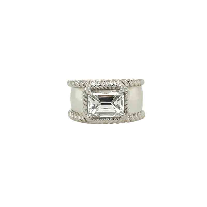 One white gold ring features a prong set emerald cut diamonds with a crafted of twisted rope design encrusted in a plated band . The ring rests in a white background.