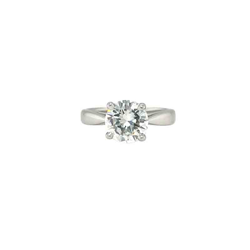 Silver ring in a prong set securing round cut diamond in a simple plain band on a white background
