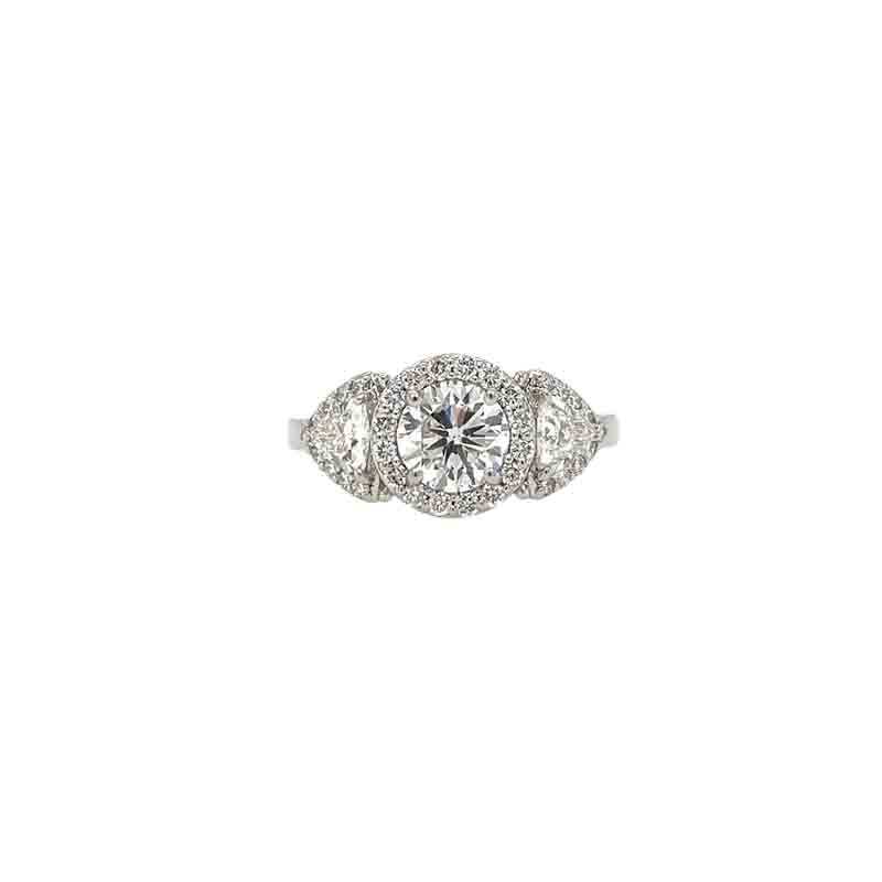 One white gold ring with a central focal point of three halo, round cut diamonds, accompanied by two pear-shaped diamonds on each side, and surrounded by smaller diamonds. The ring sets against a white background.